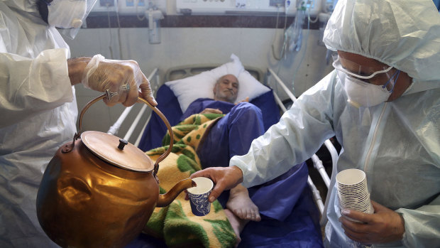 Paramedics treat a patient infected with the new coronavirus, at a hospital in Tehran, Iran.