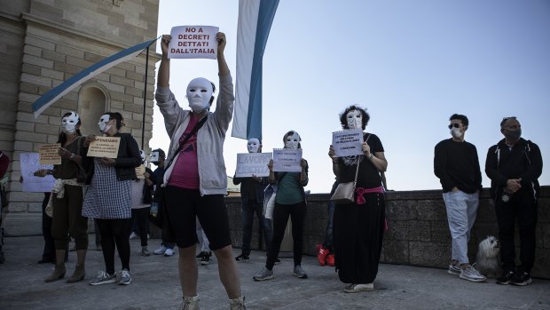 Protesters demanding an end to the coronavirus lockdowns in front of the government headquarters in San Marino, Italy.