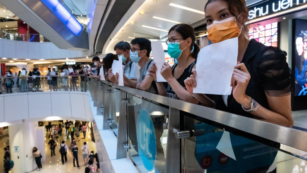 Protesters hold up blank papers during a demonstration in a mall in Hong Kong, which could be in violation of new legislation. 