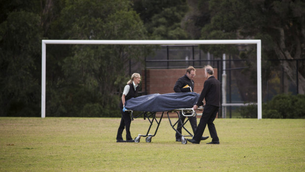Police remove a woman's body from a Princes Park oval. 