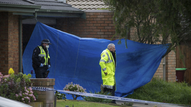 A tarp covered the garage and roller door at the front of the property in Cranbourne North after a 36-year-old woman was found dead.