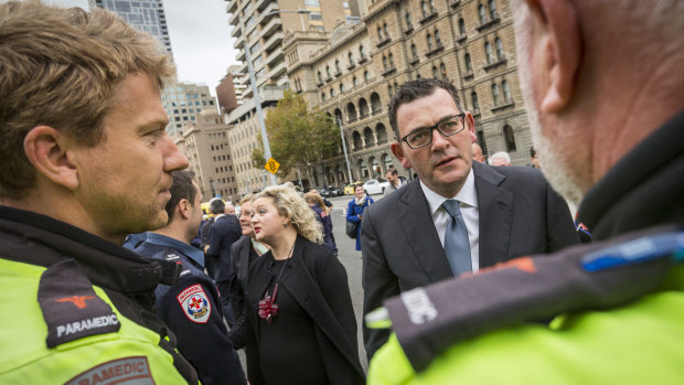 Premier Daniel Andrews speaks to paramedics before making an announcement regarding the health and safety of emergency service workers outside Parliament House.