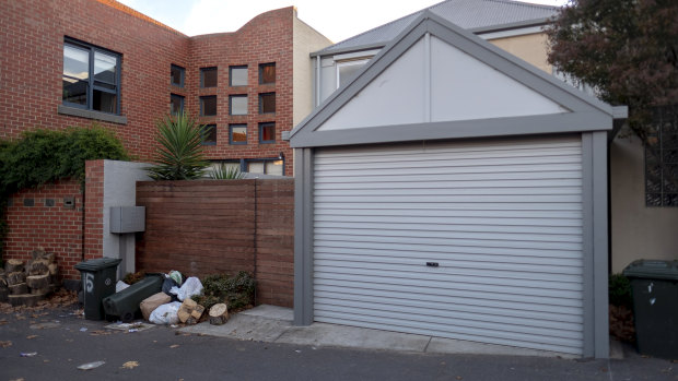 Bags of garbage litter the back gate and garage of a house where a rowdy party was held in North Melbourne.