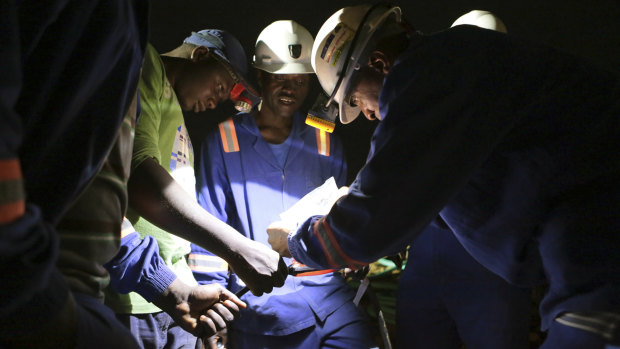 Established miners fix broken equipment used to help rescue dozens of artisanal miners, who are feared dead after rains flooded the mines last week.
