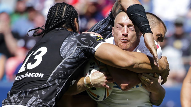 Running blind: England's James Roby is wrapped up by Martin Taupau, left.