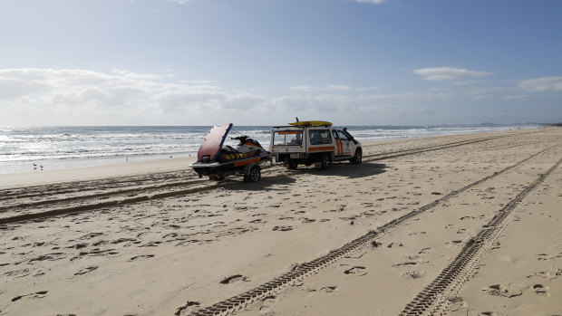 A surf lifesaving crew drives past the scene at Surfers Paradise where a baby's body was found.