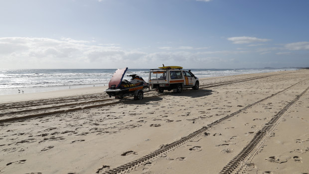A surf lifesaving crew drives past the scene at Surfers Paradise where the baby's body was found.