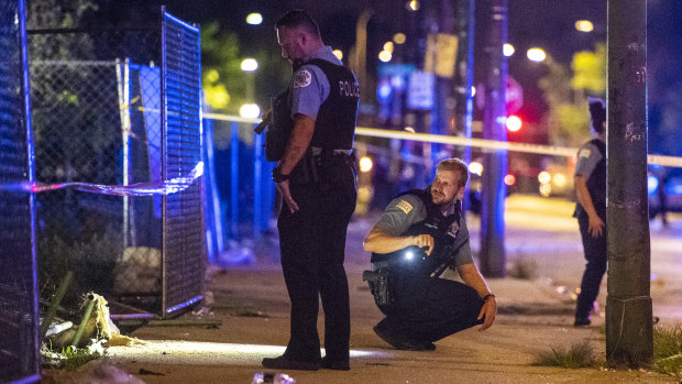 Police investigate the scene where multiple people were shot in Chicago on Saturday. 