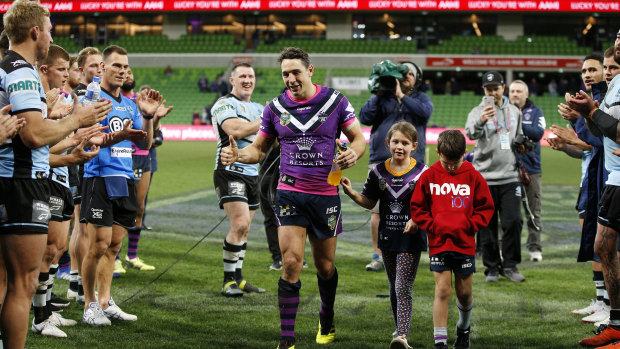 Retiring great: Storm veteran Billy Slater walks off with his children through a Sharks guard of honour.