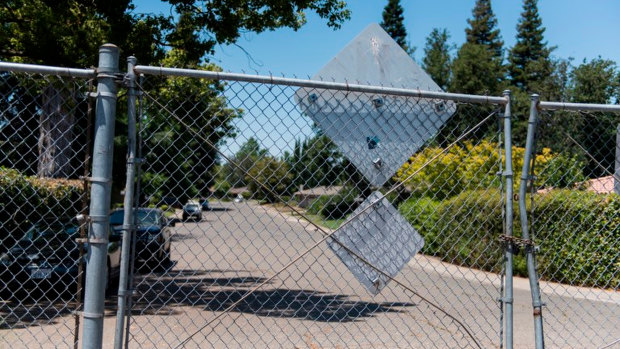 The levee behind this fence led to areas of thick brush and the American River, which the suspect often used to make his escape. 