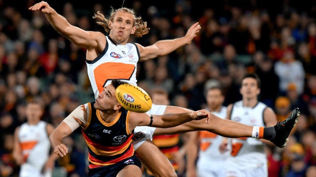 Nick Haynes of the Giants and Lachlan Murphy of the Crows battle for the ball.