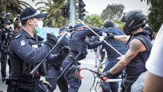 A police officer wrestles with a protester outside the National Gallery of Victoria.