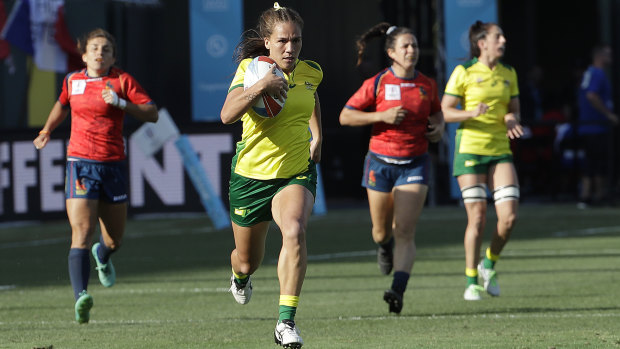 Australia's Evania Pelite runs past Spanish players to score one of her three tries during the Women's Rugby Sevens World Cup in San Francisco on Saturday (AEST).