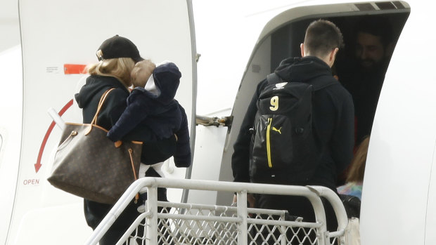 Richmond's Trent Cotchin and his family board a flight to Queensland earlier this month.