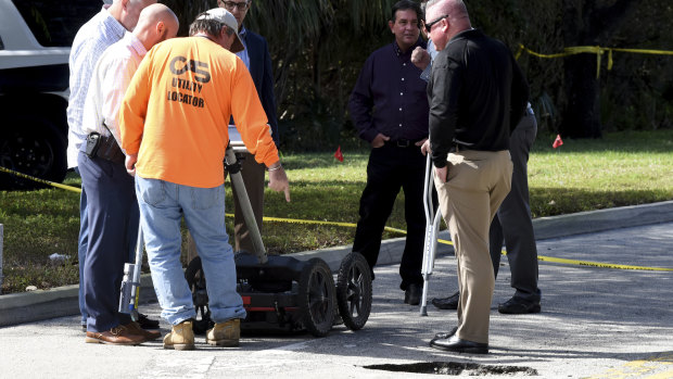 FBI and local police look at what authorities initially thought was a strange pothole in a suburban Florida street.