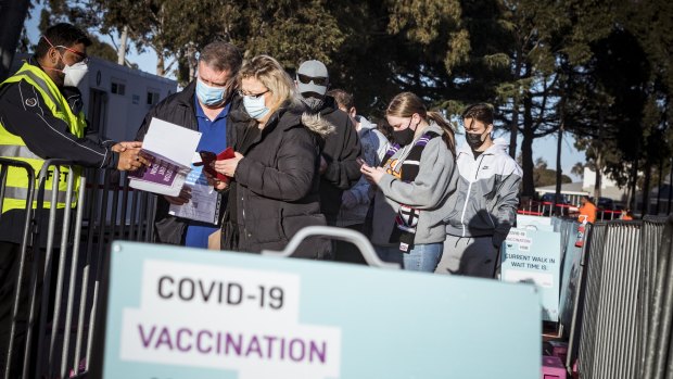 People checking in before they receive their COVID-19 vaccinations at the Melbourne Showgrounds vaccination site on Wednesday. 