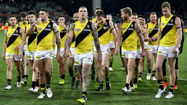 Dustin Martin leads the dispirited Tigers off after the loss to Adelaide.