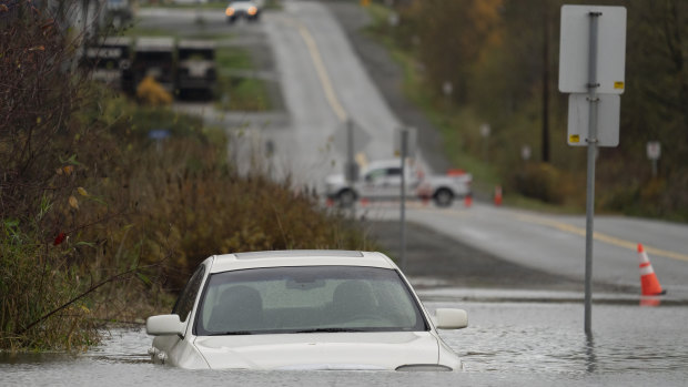 A vehicle is submerged in flood waters along a road in Abbotsford, British Columbia.