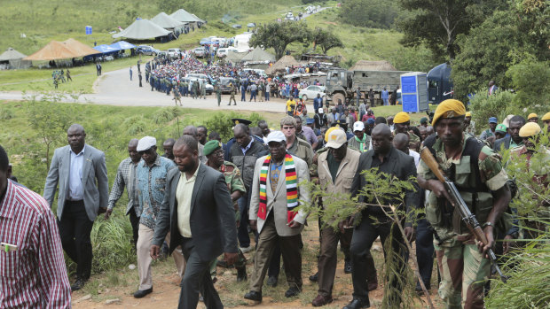 Zimbabwean President Emmerson Mnangagwa, centre with scarf, visits Chimanimani.