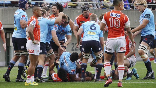 Try blitz: The Waratahs celebrate after another try in a high-scoring affair at Chichibunomiya Rugby Stadium.