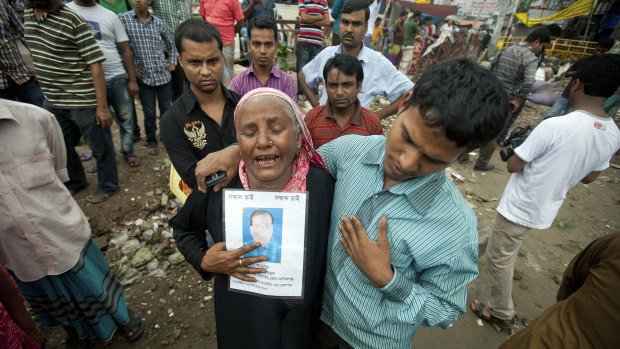 A woman holds a picture of her son, who went missing in the Rana Plaza building collapse in 2013 in Bangladesh.