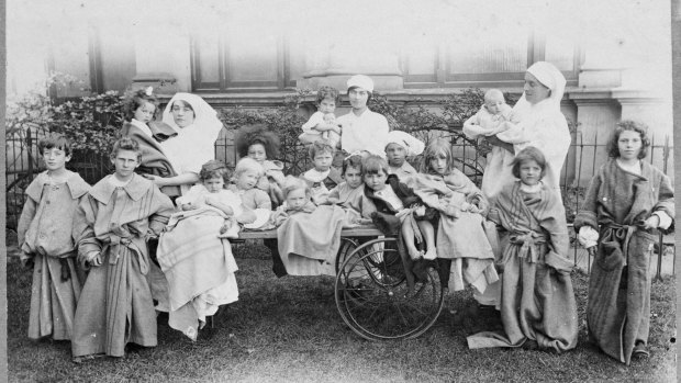 Nursing staff with patients outside of the Melbourne Exhibition Building. 