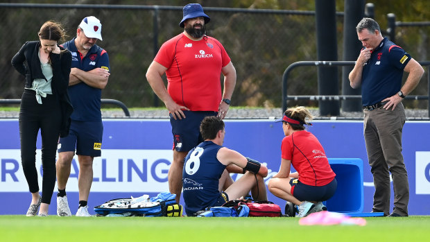 Melbourne medical staff, as well as Alan Richardson, attend to star defender Jake Lever after he fainted during training at Casey Fields. 