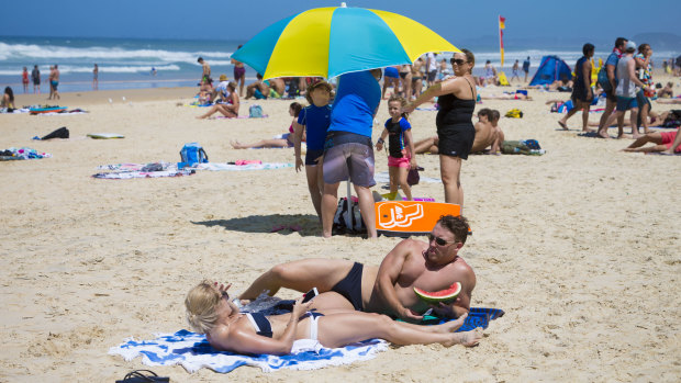 Swimmers and sunbakers bask in hot weather on the Gold Coast beaches.