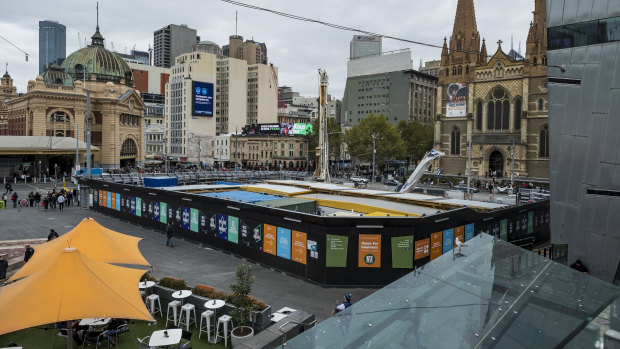 The tourist information centre booth at Federation Square has made way for the entrance to a new rail station being built as part of the Metro Tunnel project.