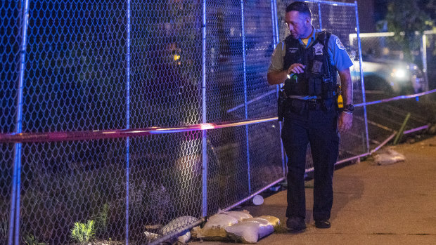 An officer scours a scene of one of several shootings in Chicago over the weekend.