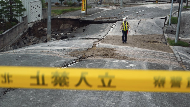 A security guard walks on an earthquake-damaged street in Kiyota, outskirts of Sapporo.