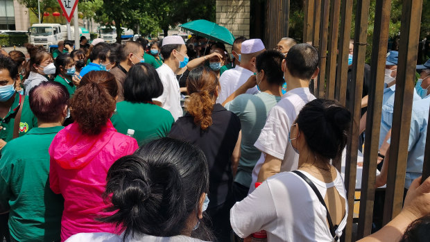 Citizens who visited or live near Xinfadi Market queue for a nucleic acid test at a sports centre in Beijing.