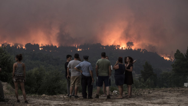 People observe as fire gets closer to the village of Monchique, Algarve, Portugal.