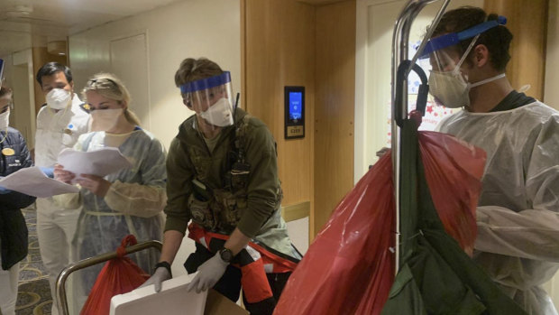 Medical personnel don protective equipment after delivering virus testing kits to the Grand Princess cruise ship off the coast of California. 