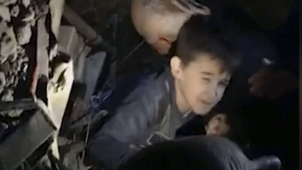 People work to free a young boy from a collapsed building in the coastal town of Durres.