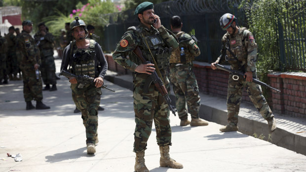 Afghan security personnel gather near the prison.
