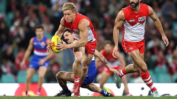Isaac Heeney of the Swans gathers the ball over Tom Liberatore.