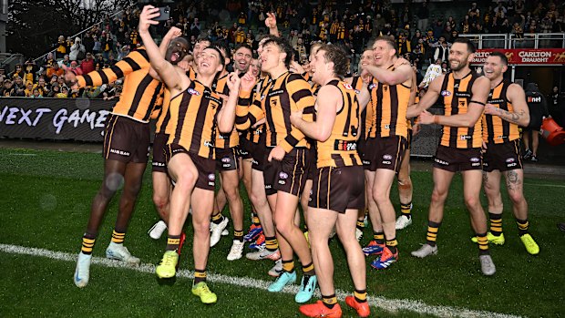 Hawks players celebrate with selfies in Launceston.
