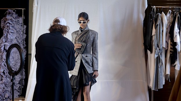 Stylist Jolyon Mason locks in a look with a photograph of the model.