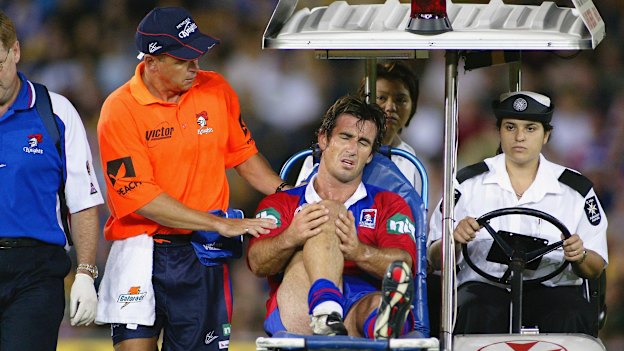 Andrew Johns is taken off the field after injuring his knee during a league match in 2004 in Sydney.