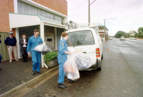 Officers remove items from a former bank building at Snowtown in May 1999.