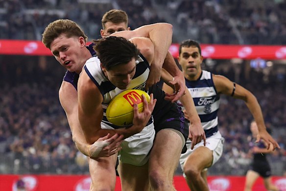 Nathan O’Driscoll of the Dockers tackles Oliver Henry of the Cats.