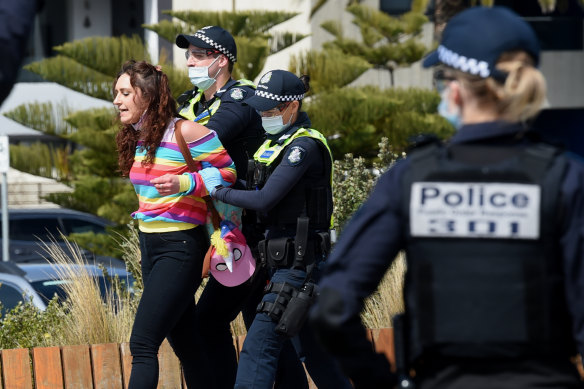 Police arrest a protester in St Kilda on Saturday.