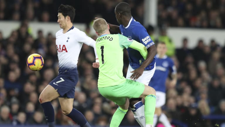 Everton goalkeeper Jordan Pickford collides with teammate Kurt Zouma, as Spurs' Son Heung-min scores.