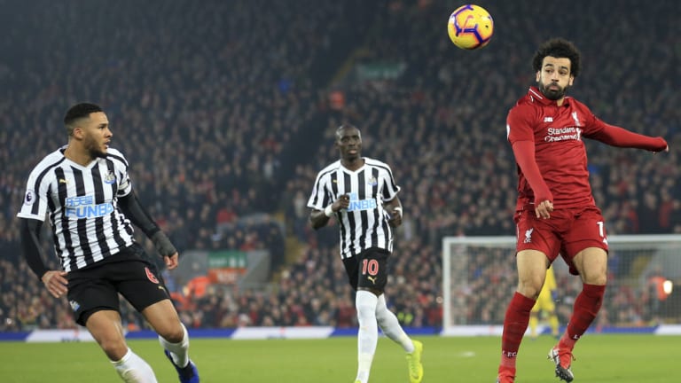 Liverpool's Mohamed Salah (right) jumps for a header against Newcastle.