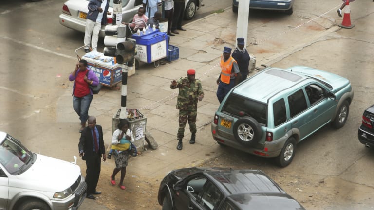 A soldier controls a fuel queue in Harare on Tuesday. 