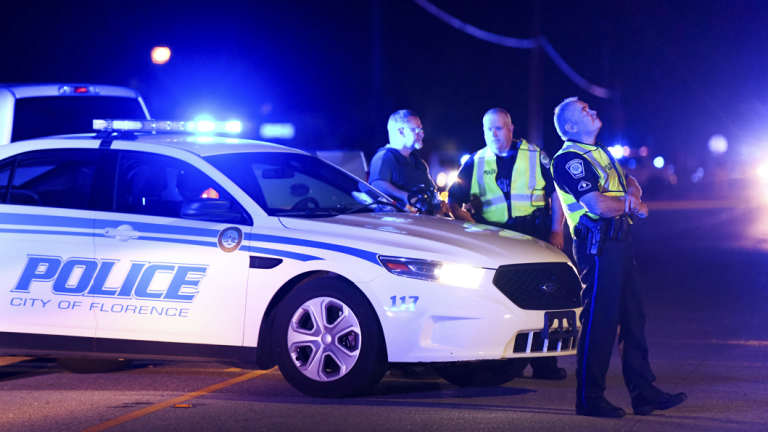 Police direct traffic near the Vintage Place neighbourhood where law enforcement officers were shot.