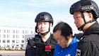Chinese guards escort alleged scam boss Chen Zhi (centre) off a China Southern plane in Beijing, after his extradition from Cambodia.