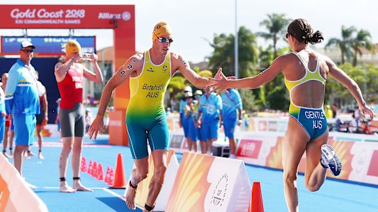 Australian team relay members Jake Birtwhistle and Ashleigh Gentle change over during the triathlon mixed team relay at the Gold Coast Commonwealth Games in 2018. The pair will both represent Australia in Tokyo.