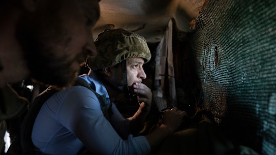 In an undated photo, President Volodymyr Zelenskyy looks at a front-line position from a shelter as he visits eastern Ukraine.